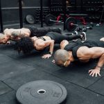 Fitness enthusiasts performing push-ups in a Mexico City gym. Emphasizing teamwork and strength.
